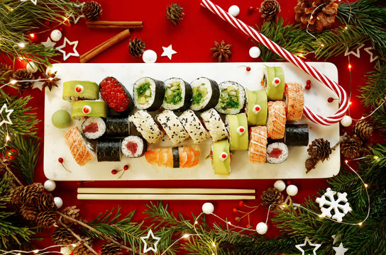 Christmas sushi set flatlay with Christmas decorations on red background