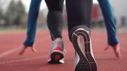 Back view of a young athlete getting ready for the race on a running track . - Powered by Adobe