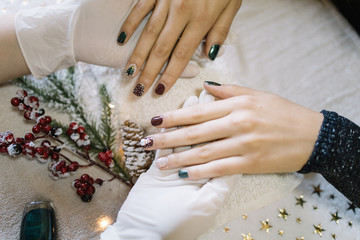 Girl showing her Christmas manicure at nail salon