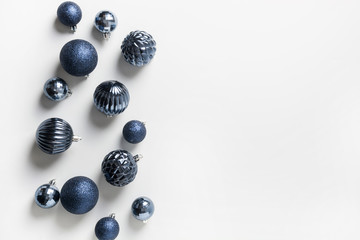 Christmas frame of classic blue balls on neutral pastel grey. Top view. Xmas border for wishes. Holiday greeting card.