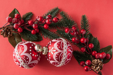 many red christmas balls on red background with copy space. New Year greeting card.