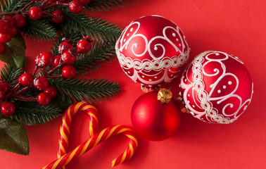 many red christmas balls on red background with copy space. New Year greeting card.