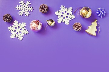 Winter holiday design. Elegant Christmas and New Year decoration in purple color. Snowflakes, gold balls and pine cones. Mockup and banner