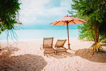 Obraz na płótnie Canvas Two beach chairs on tropical vacation, relax at sea