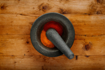 Plan view of pestle & mortar and ground spices, shot on a wooden background, with copy space
