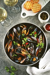 Fresh wild mussels in shells with green onions, garlic, parsley, chili pepper, white wine and olive oil. Top view. 