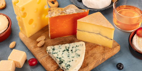 Cheese board panorama. Blue cheese, red Leicester, Emmental and others with wine