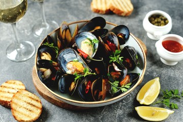 Fresh wild mussels in shells with green onions, garlic, parsley, chili pepper, white wine and olive oil. Top view. 