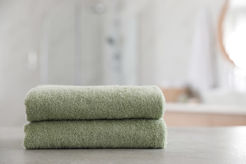 Fototapeta na wymiar Stack of clean towels on table in bathroom