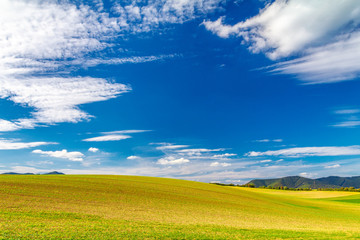 Rural landscape, field with blue sky and clouds in the background at a sunny summer day. Rajec Valley area, Slovakia, Europe.