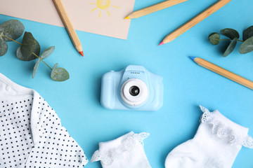 Flat lay composition with toy camera on light blue background. Future photographer