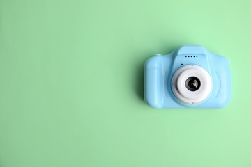 Light blue toy camera on light green background, top view with space for text. . Future photographer