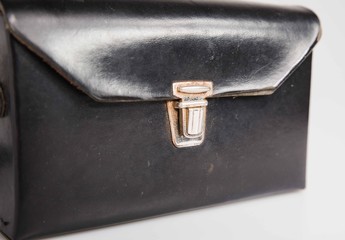 London, England, 29/11/19 Vintage retro leather camera bag with a metal locking mechanism shot isolated on a white background used for a print T3 old camera carry case.