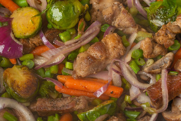 Fototapeta na wymiar Vegetables fried with meat, in a pan close-up, culinary background