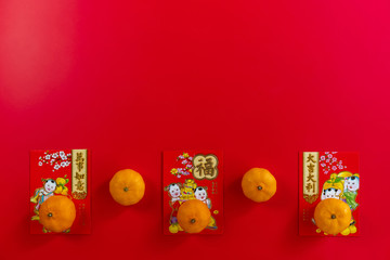 Chinese new year festival decorations.,  Red packet and oranges on a red background with copy space for text. Chinese characters is means refer to fortune, wealth, rich, successful.