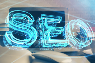 Multi exposure of table with computer and seo drawing hologram. Search optimization concept.
