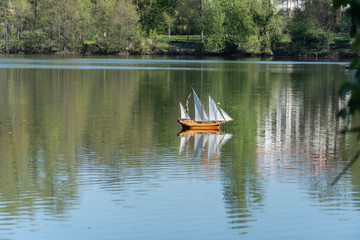 Wooden toy galleon ship sailing in a lake