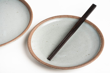 A Pair Of Chopsticks With Stoneware Plate