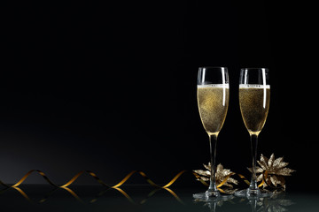 Two glasses of champagne ready to bring New Year on a black background.