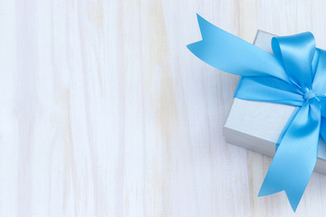 gray silver gift box  new year Packed present container with blue ribbon on Vintage white wooden board background for holiday concept with copy space, top view pattern.