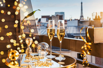 Celebration of New Year or Christmas concept. Two glasses with champagne and golden decorations on...