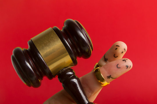 Purposal devorce creative concept. Painted happy fingers smiley in love against red background with court libra