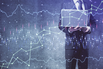 Forex graph with businessman working on laptop on background. Concept of hardworking. Multi exposure.