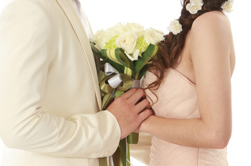 Bride and groom holding a bouquet of white roses on a white background.