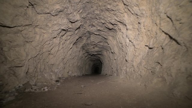 Speleology artificial cave dark tunnel excavation underground. Old adit for the extraction of metal and rocks