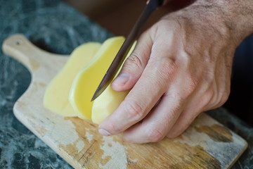 closeup of a hand cutting a potato with a knife