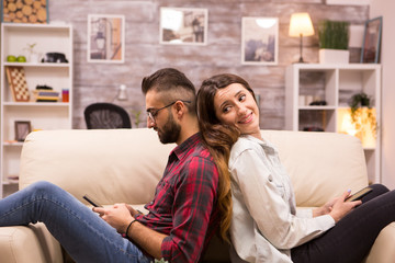 Girlfriend looking at her boyfriend while sitting back to back