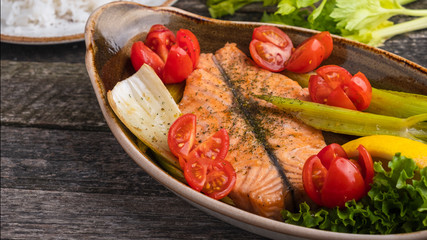 Delicious salmon fillet baked with tomatoes and stern celery. Diet food concept. Copy space
