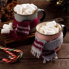 Christmas marshmallows and New Year decorations and sweet canes on a wooden background. Winter holidays, new year mood. Copy space. Close up.