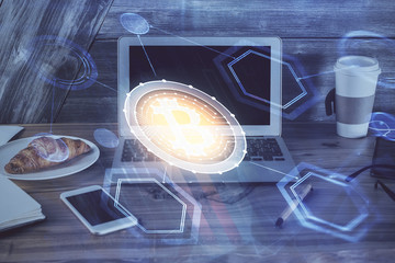 Double exposure of blockchain theme hologram and table with computer background. Concept of bitcoin crypto currency.