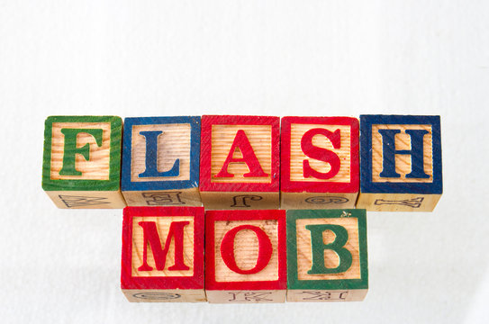 The term flash mob displayed visually on a white background using wooden toy blocks image with copy space