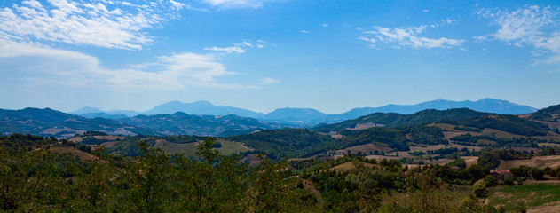 Fototapeta na wymiar Panoramic photo - mountain ranges going into the distance against a blue sky