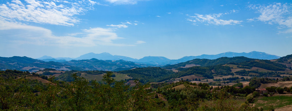 Panoramic photo - mountain ranges going into the distance against a blue sky © igor_zubkov