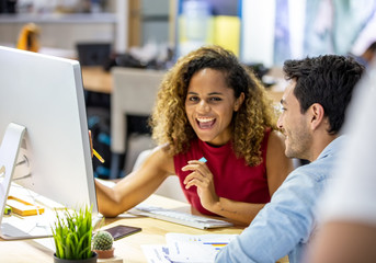 Working together on project. Two young business colleagues working on computer