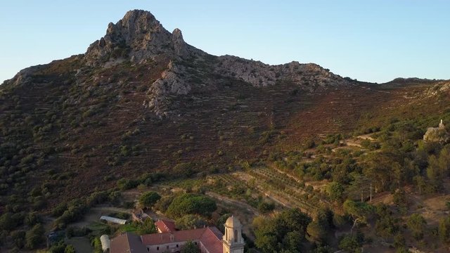 Aerial drone backward flight footage to the ancien Corbara abbey in the Corse island, France.