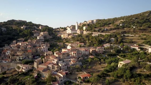 Aerial drone forward flight footage in the afternoon time of Corbara village in the Corse island, France.