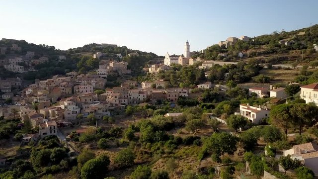 Aerial drone forward flight footage in the afternoon time to the Corbara village in the North of Corse island, France.