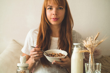 Healthy organic nutrition. Woman enjoying breakfast with oatmeal in bed, free space. 