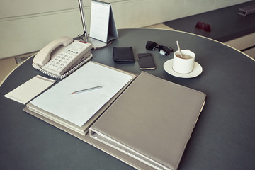 Business working table with business and personal objects on it in a hotel room