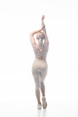 back view of blonde girl in beige leggings twerking in smoke isolated on white