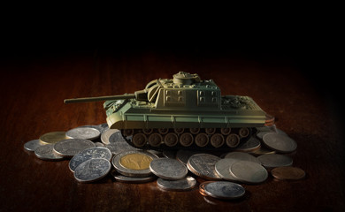 Small plastic tank on money coins.