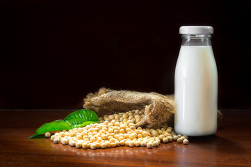 Soy milk bottle with soy beans spill from sack.