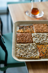 Turkish Homemade Snacks Biscuit with Sunflower Seeds, Sesame and Dill /Crispy Yaprak Galeta with Traditional Tea on Tray.