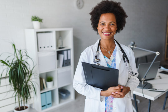 Portrait Of Female African American Doctor Standing In Her Office At Clinic