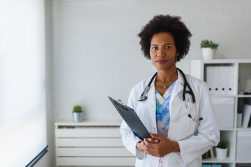 Portrait of female African American doctor standing in her office at clinic