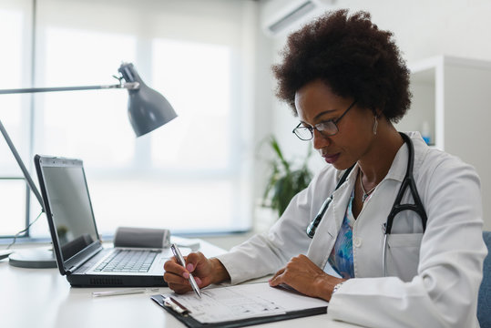 Serious Concentrated African American Doctor Working In Her Office At Clinic